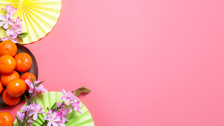 Chinese or lunar new year flat lay with paper decorations, mandarins and flowers on pinkの写真素材