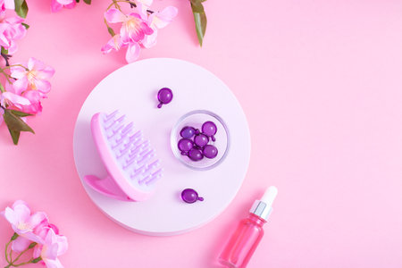Scalp Massage and Cleansing Shampoo Brush with hair vitamins on pink backgroundの写真素材