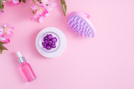 Scalp Massage and Cleansing Shampoo Brush with hair vitamins on pink backgroundの写真素材