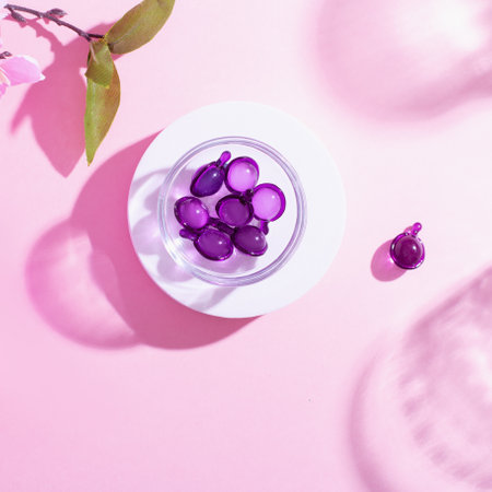 Vitamin capsules in pink, purple color, closeup on pink background, top viewの写真素材