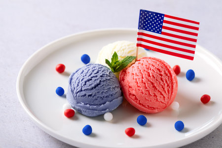 Patriotic colors ice cream scoops with American flag on white plateの写真素材
