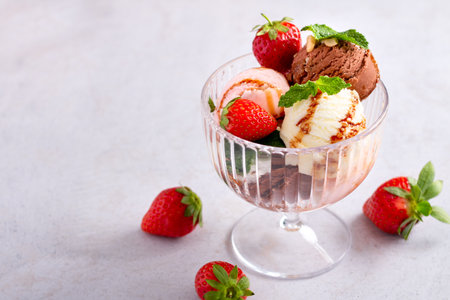 Ice cream scoops in a glass bowl on light gray tableの写真素材