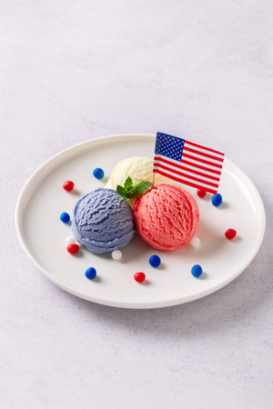 Patriotic colors ice cream scoops with American flag on white plateの写真素材