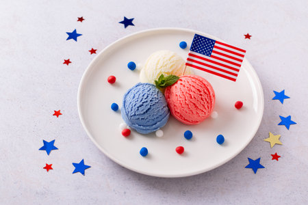 Patriotic colors ice cream scoops with American flag on white plateの写真素材