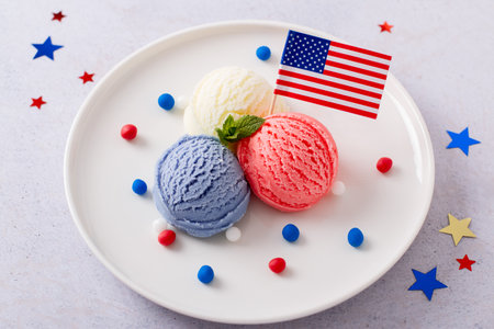 Patriotic colors ice cream scoops with American flag on white plateの写真素材