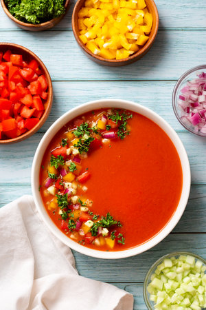 Spanish tomato gazpacho cold soup styled and decorated in white plate on wooden tableの写真素材