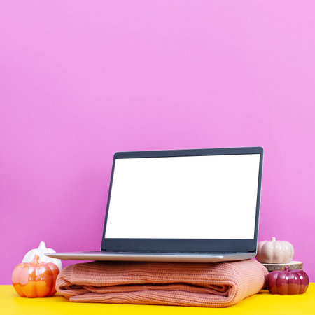 Laptop on table with minimal autumn or fall season decor, yellow and purple pastel color, seasonal business conceptの写真素材