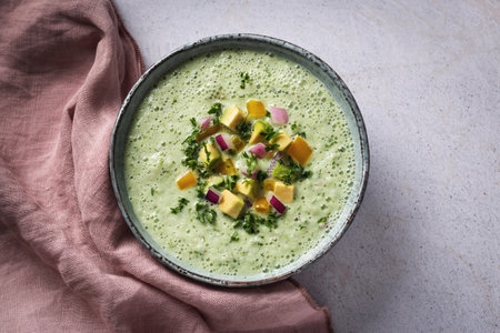 Green cucumber gazpacho cold cream soup styled and decorated in rustic bowlの写真素材