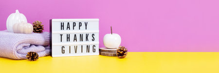Lightbox with text Happy Thanksgiving with ceramic pumpkins on table, vivid color background. Autumn or fall mock up with seasonal decor still life, web bannerの写真素材