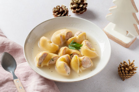 Traditional Catalan Christmas dish Escudella in white plate on table, stuffed pasta in meat broth, top view, copy spaceの写真素材