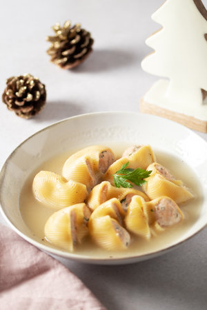 Traditional Catalan Christmas dish Escudella in white plate on table, stuffed pasta in meat broth, top view, copy spaceの写真素材