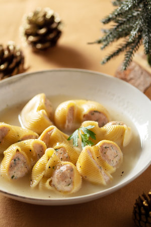 Traditional Catalan Christmas dish Escudella in white plate on table, stuffed pasta in meat broth, top view, copy spaceの写真素材