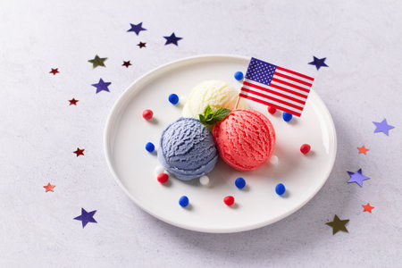 Patriotic colors ice cream scoops with American flag on white plateの写真素材