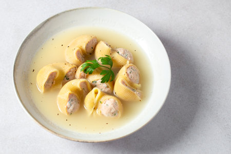 Traditional Catalan Christmas dish Escudella in white plate on table, stuffed pasta in meat broth, top viewの写真素材