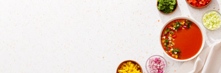 Spanish tomato gazpacho cold soup styled and decorated in white plate with ingredients on white table, top view, web bannerの写真素材