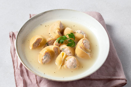 Traditional Catalan Christmas dish Escudella in white plate on table, stuffed pasta in meat broth, top view, copy spaceの写真素材