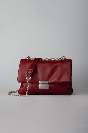 Deep red leather handbag or clutch on grey backgroundの写真素材