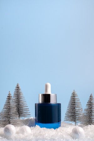 Winter skincare beauty concept with face serum on a blue background, front viewの写真素材