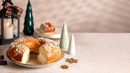 Spanish Three kings cake on decorated table with Christmas tree and burning candles, celebration of Three Kings Dayの写真素材