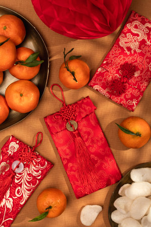 A plate of oranges and red gift envelopes on a beige table, symbolizing the Chinese New Year celebration and traditionsの写真素材