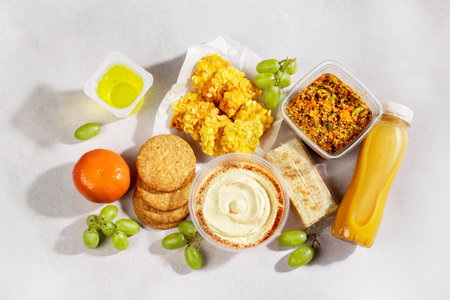 Premade quinoa and bulgur salads on table with gluten free nuggets and fresh smoothies. Quick gluten free food to eat on the go or for lunch break, time saving ready to eat healthy mealsの写真素材