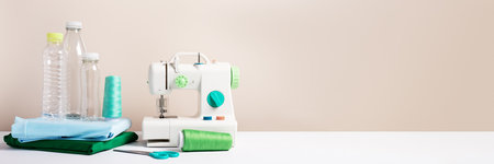 Plastic bottles, sewing machine and folded t-shirts still life, concept of clothes made from recycled plastic bottles, web banner, copy spaceの写真素材