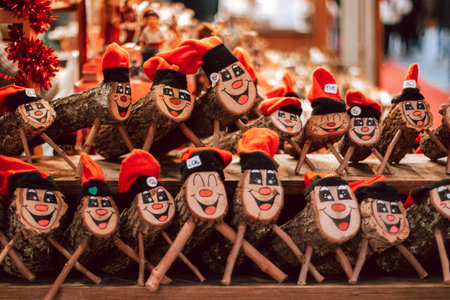 A collection of traditional Catalan Christmas decorations made from logs with painted faces, red hats, and wooden legs, displayed at a festive market stall.の写真素材