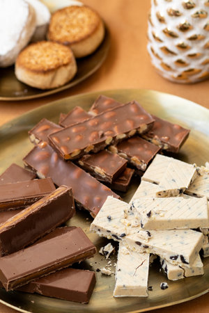 Christmas Spanish holiday treats, chocolate turron with whole almonds, creamy nougat, and polvoronesの写真素材