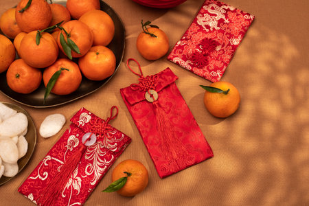 A plate of oranges and red gift envelopes on a beige table, Chinese New Yearの写真素材