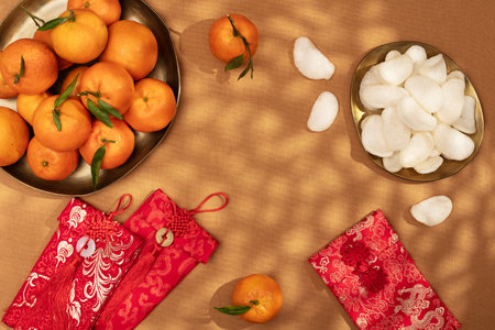 A plate of oranges and red gift envelopes on a beige table, Chinese New Yearの写真素材