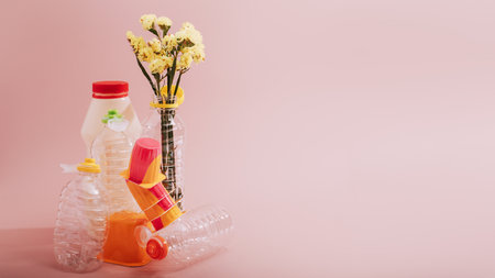 Conceptual balancing still life with plastic and flower on pink, theme of recycling, waste managementの写真素材