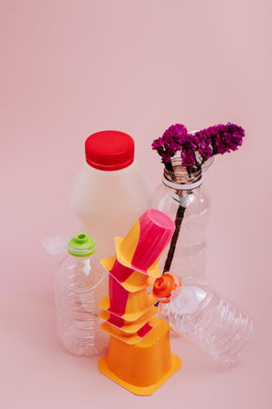 Conceptual balancing still life with plastic and flower on pink, theme of recycling, waste managementの写真素材