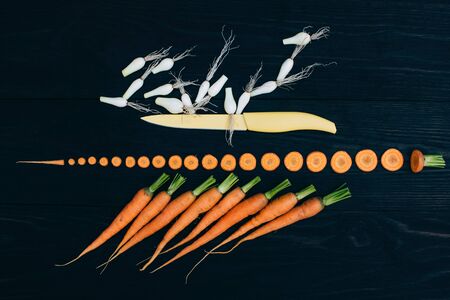 young carrots isolated on black background, cooking fresh vegetables conceptの写真素材