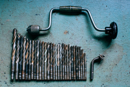 manual old drill on blue table background, working tools, grunge background