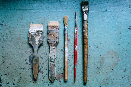 old grungy paint brushes on blue table background, grunge background