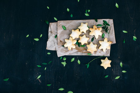 Fresh festive cookies in the shape of stars on a dark wooden background