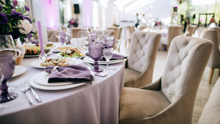 Table set. Beautiful wedding restaurant decoration in purple tones: purple glasses, purple flowers...