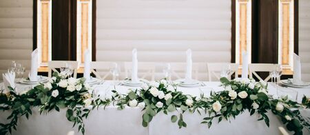Beautiful table decoration with green leaves and gold candlesticksの写真素材
