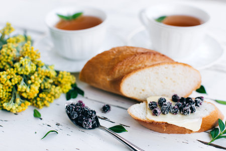 Delicious sandwich with blueberries and butter on a white background