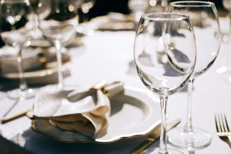 table set for dinner  with wine glasses in the summer garden. Outdoor catering