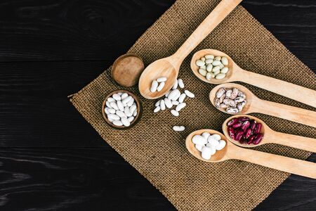 A colorful of beans in wood spoon on wood backgroundの写真素材