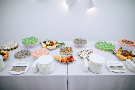 Dessert table with appetizers and cakes at a wedding party in a restaurant