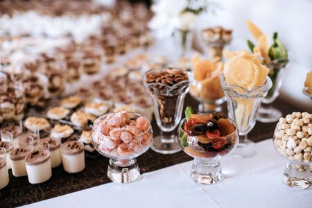 Beautiful wedding desserts made of cakes, nuts, almonds and dried fruits, candied fruitsの写真素材