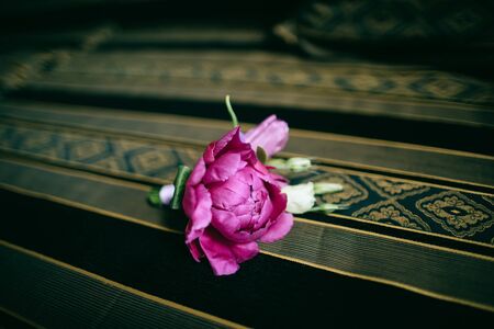 Purple peony boutonniere for groom on dark backgroundの写真素材