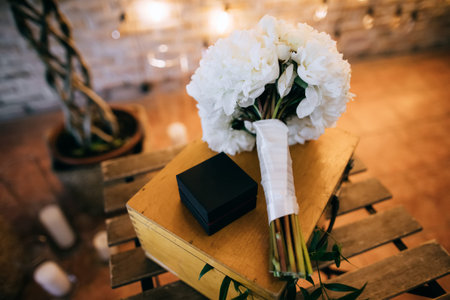 Beautiful wedding bouquet of white peonies lying on a wooden table at a wedding ceremony