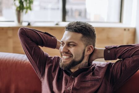 Young bearded man smiling after hard workの写真素材