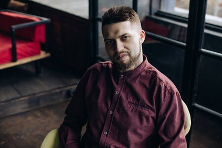 Portrait of a smiling young man in a red shirtの写真素材