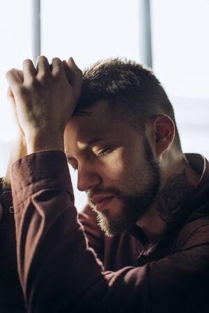 Tired man. Portrait of conceived young man depressedの写真素材