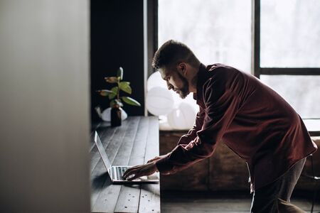 Young man working at laptop in officeの写真素材