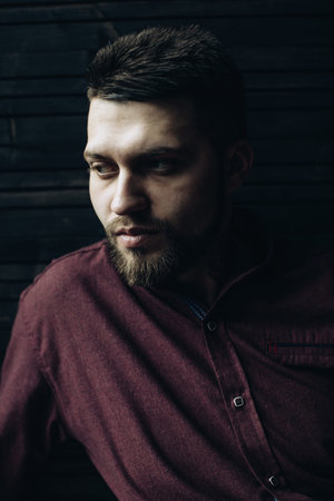 A brutal portrait of a bearded man with a tattoo on his neck
